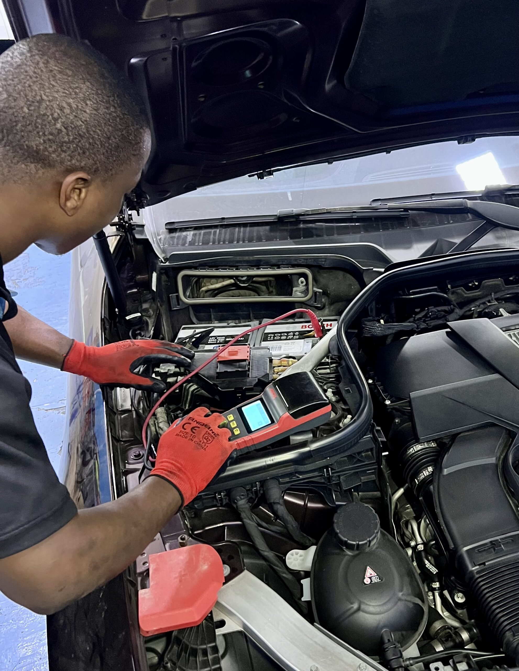 Mechanic changing battery at DMEAuto Workshop