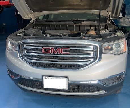Mechanic Repairing GMC Acadia in Workshop